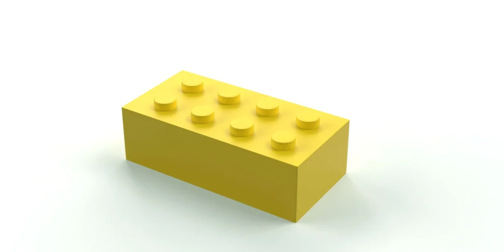 Un singolo mattoncino giallo su fondo bianco