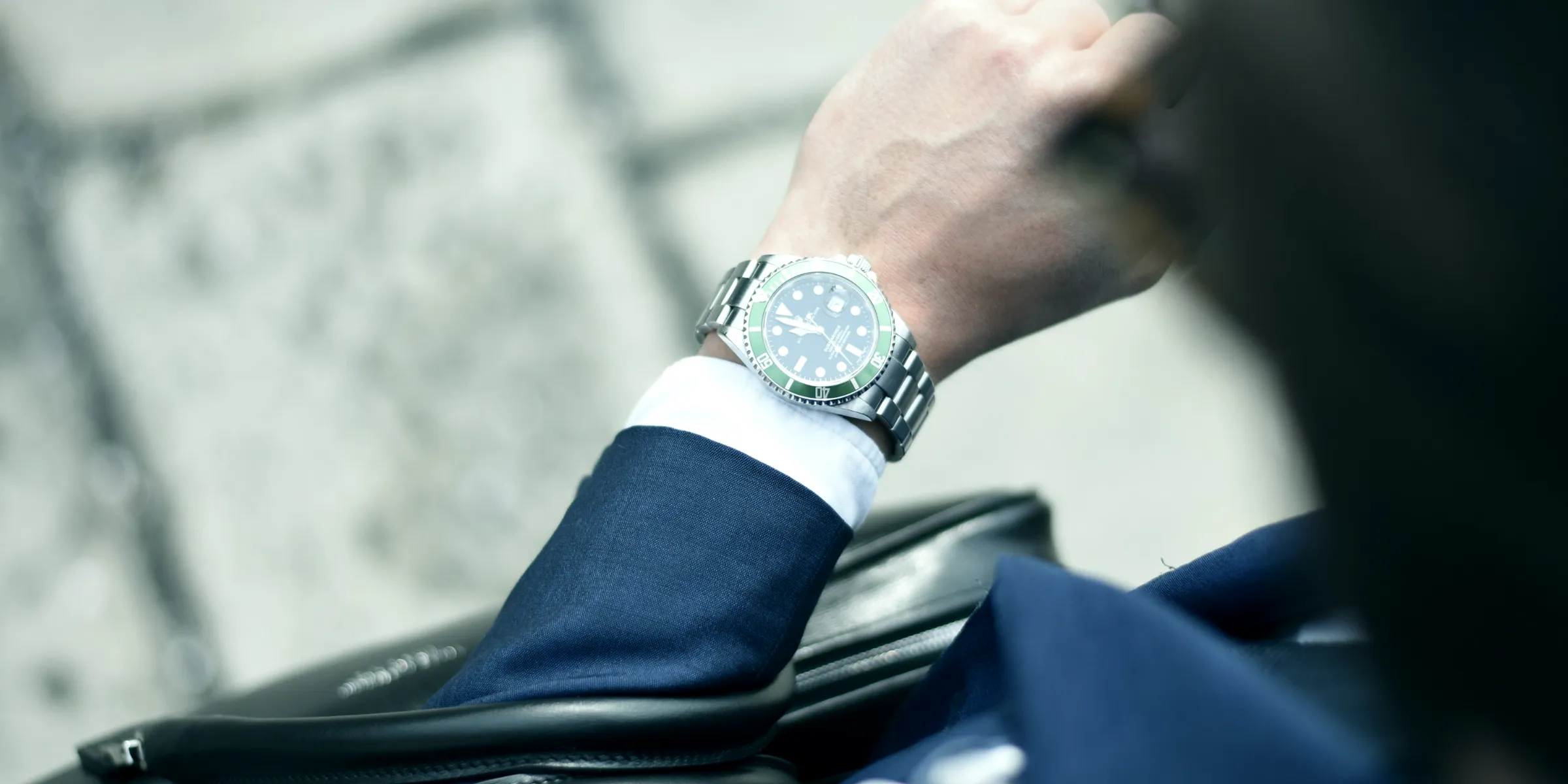 Una persona in giacca guarda l'orologio al polso