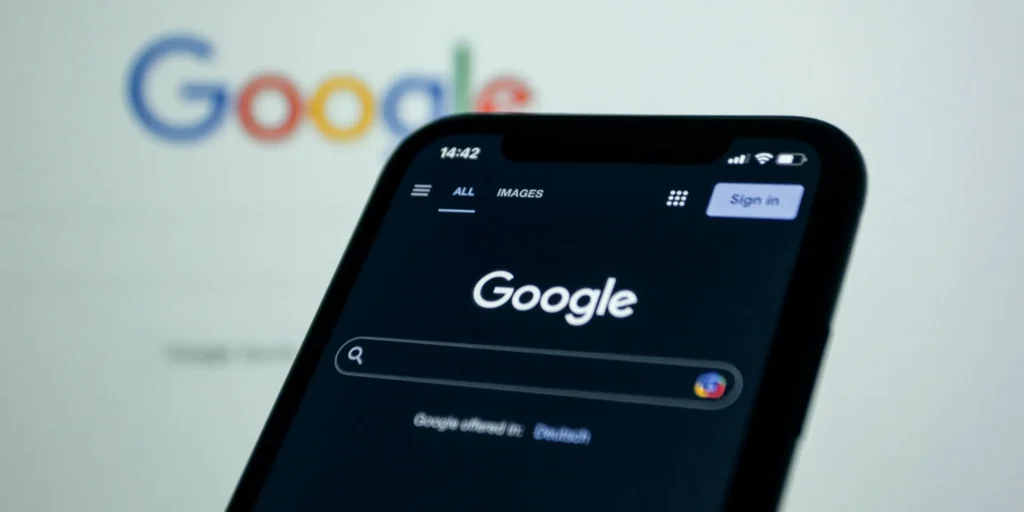 Uno smartphone con la ricerca Google aperta, davanti al logo di Google