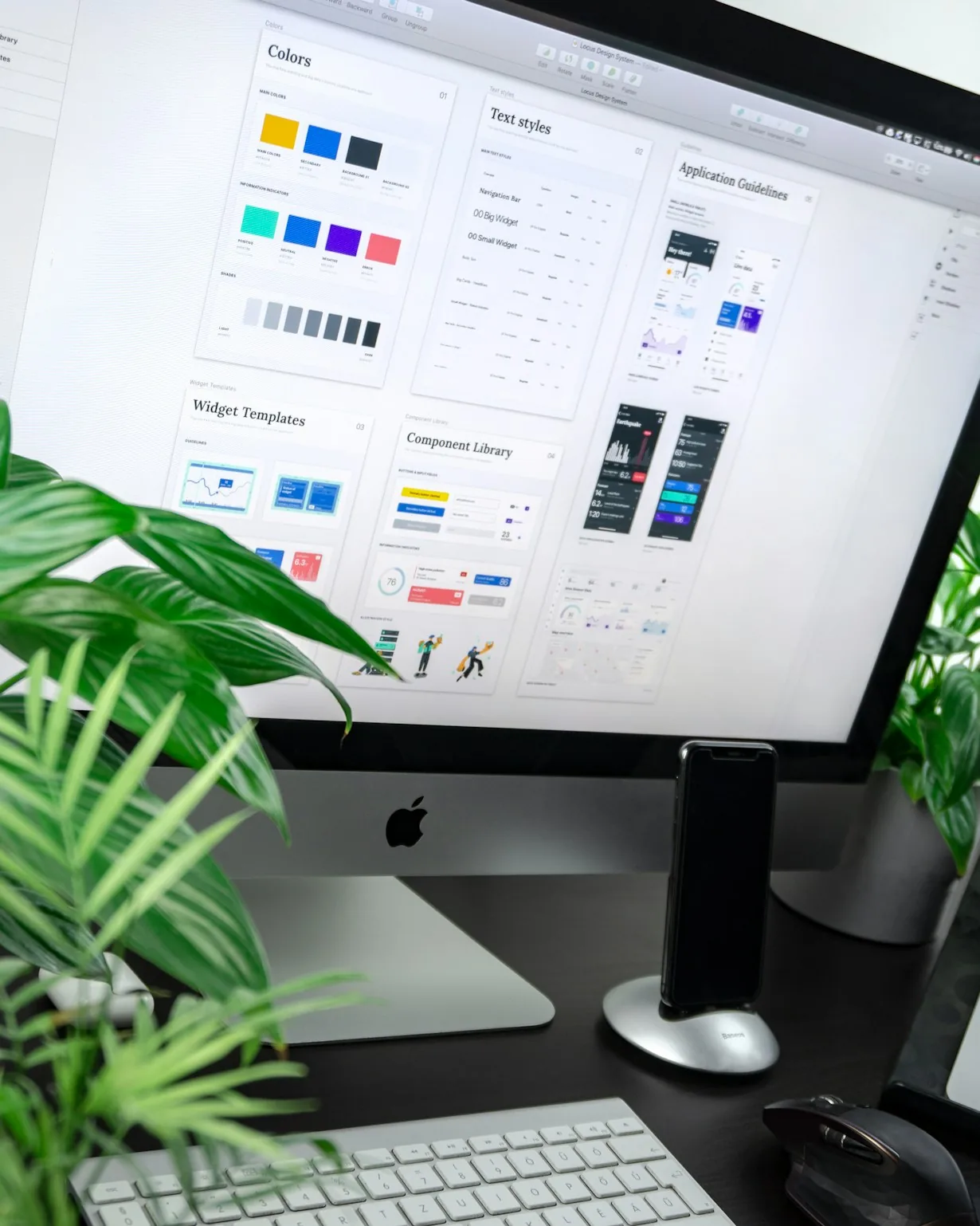 Lo schermo di un computer mostra la libreria di un design system, con colori, stili dei testi e componenti dell’interfaccia, accanto a una pianta