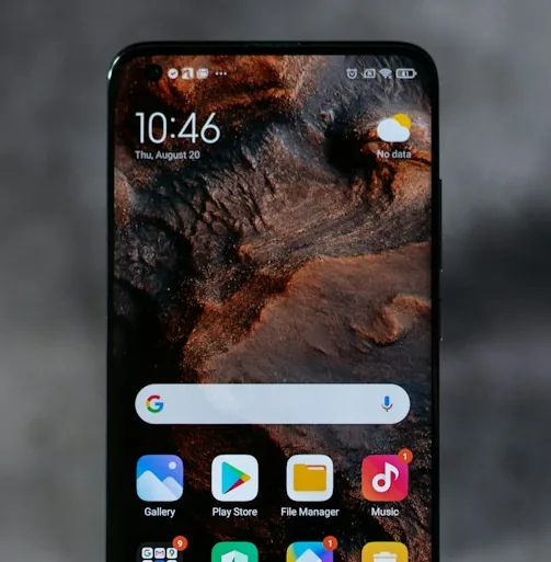 La schermata iniziale di uno smartphone con le icone delle app, su uno sfondo grigio